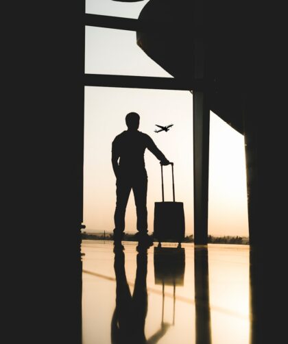 silhouette of man holding luggage inside airport