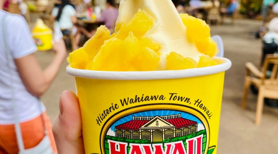 person holding a blue and yellow cup with yellow ice cream